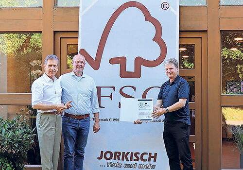 Drei Männer vor einem FSC-Banner mit Zertifikat.