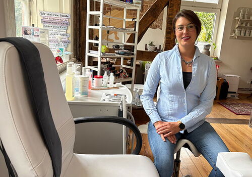 Frau sitzt in einem Schönheitsstudio auf einem Stuhl.
