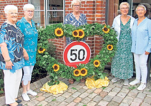 Fünf Frauen stehen mit Sonnenblumen umrahmter 50.