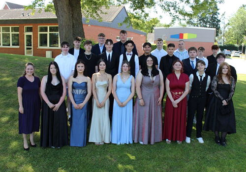 Abschlussklasse posiert im Freien für ein Gruppenfoto.