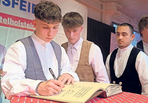 Junge Männer in traditioneller Kleidung bei einer Zeremonie.