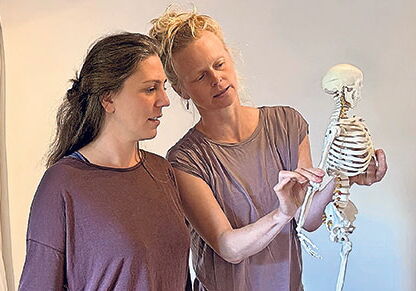 Zwei Frauen betrachten ein kleines Skelett.
