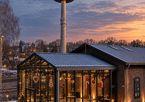 Winterliche Halle mit Turm bei Sonnenuntergang.
