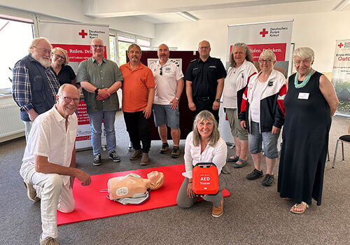 Gruppe bei Erste-Hilfe-Training mit einem AED-Trainer.