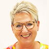 Heike Klaffke lächelndes Porträtfoto vor hellem Hintergrund.