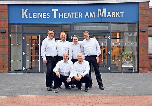 Kabarettgruppe Die Schwarzbunten vor einem kleinen Theater.