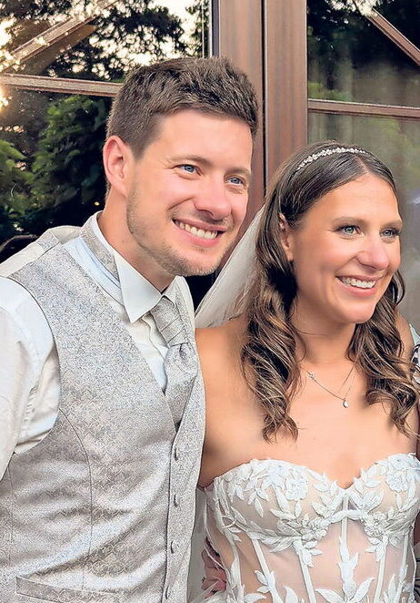 Brautpaar lächelt bei einer Hochzeit im Freien