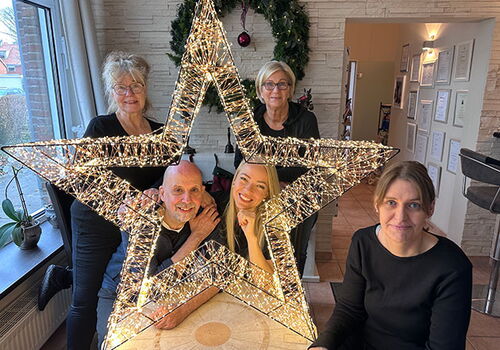Gruppe von fünf Personen mit leuchtendem Stern.