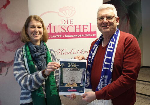 Zwei Menschen halten ein Spendenzertifikat.