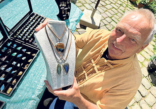 Ronny Scott präsentiert handgefertigten Schmuck im Freien.