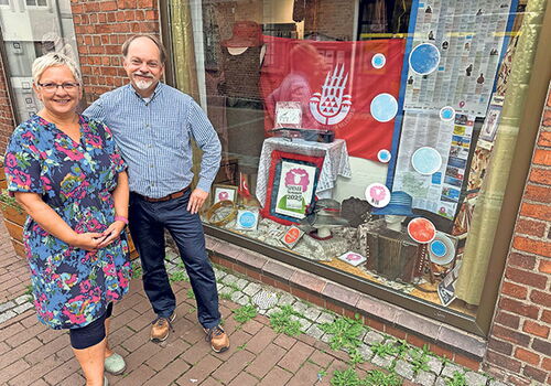 Zwei Personen vor einem dekorierten Schaufenster.