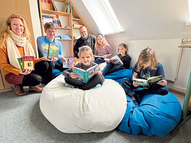 Schulleiterin Juliane Carstensen bedankt sich bei Heiko Brandt und Steffen Büttner (hi.v.li.) vom Förderverein für die Bücherspende.  Bei den Kindern kommt der neue Lesestoff gut an. Foto: ohe