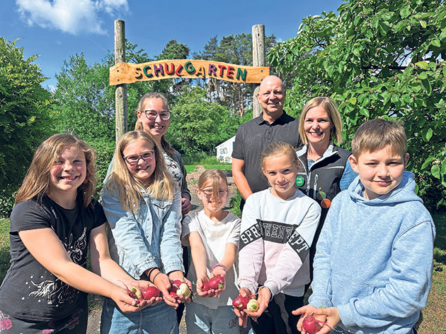 Leezen Schulgartenprojekt: Schüler und Ernte im Garten Kinder im Schulgartenprojekt in Leezen mit geernteten Radieschen