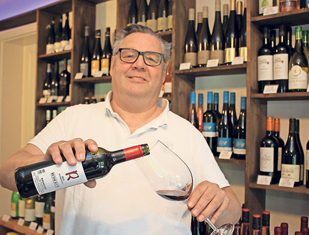 Frank Pagel, Inhaber Wein Welt, mit Wein Frank Pagel mit Weinflasche