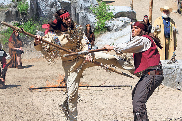 Kampf zwischen Winnetou und Ik Senanda auf der Bühne. Winnetou und Ik Senanda im Kampf auf sandigem Boden.
