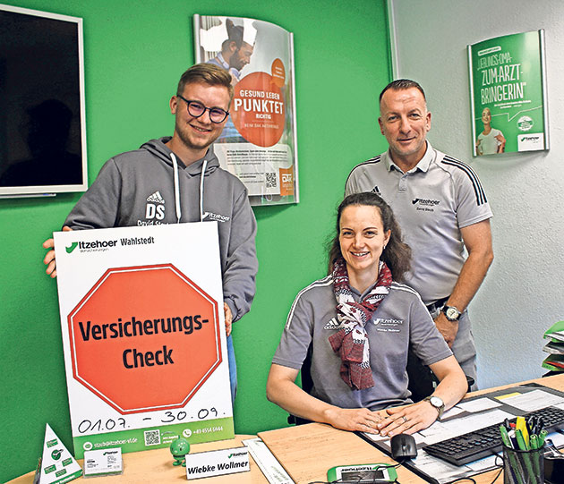 Büroszene mit Versicherungs-Check-Schild Drei Personen mit einem Versicherungs-Check-Schild im Büro.