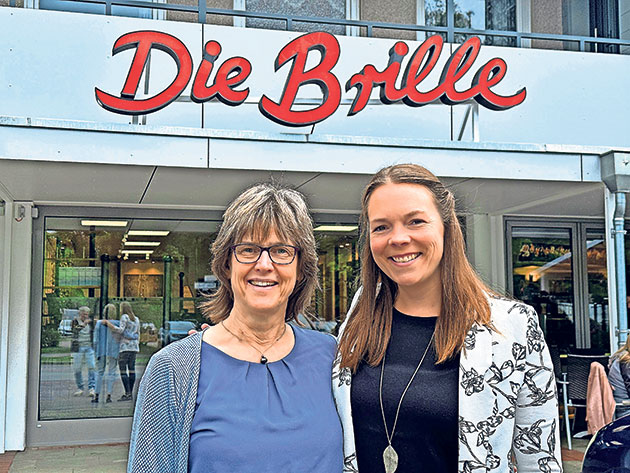Lächelnd vor dem Geschäft Die Brille Zwei Frauen lächeln vor einem Geschäft namens Die Brille.