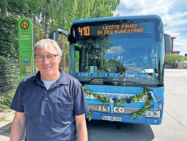 Letzte Fahrt in den Ruhestand mit Buslinie 410. Busfahrer vor dekoriertem Bus mit Ziel: Ruhestand.