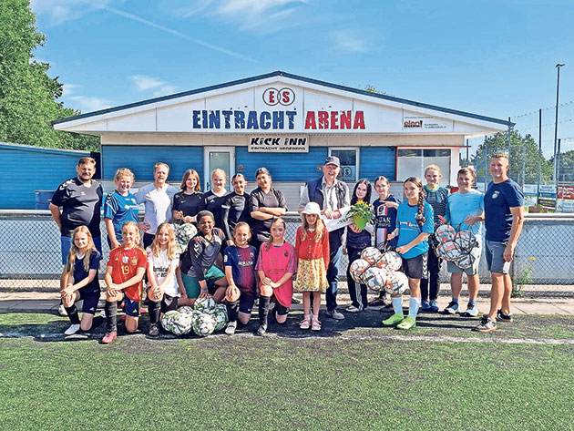 Gruppe von Fußballspielern und Trainern vor Eintracht Arena