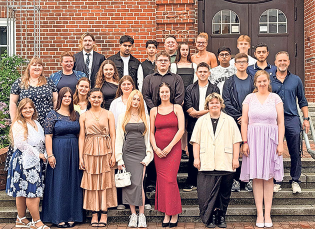 Gruppenfoto vor Backsteingebäude auf Treppe aufgenommen Gruppenfoto von Menschen auf einer Treppe vor einem Gebäude.