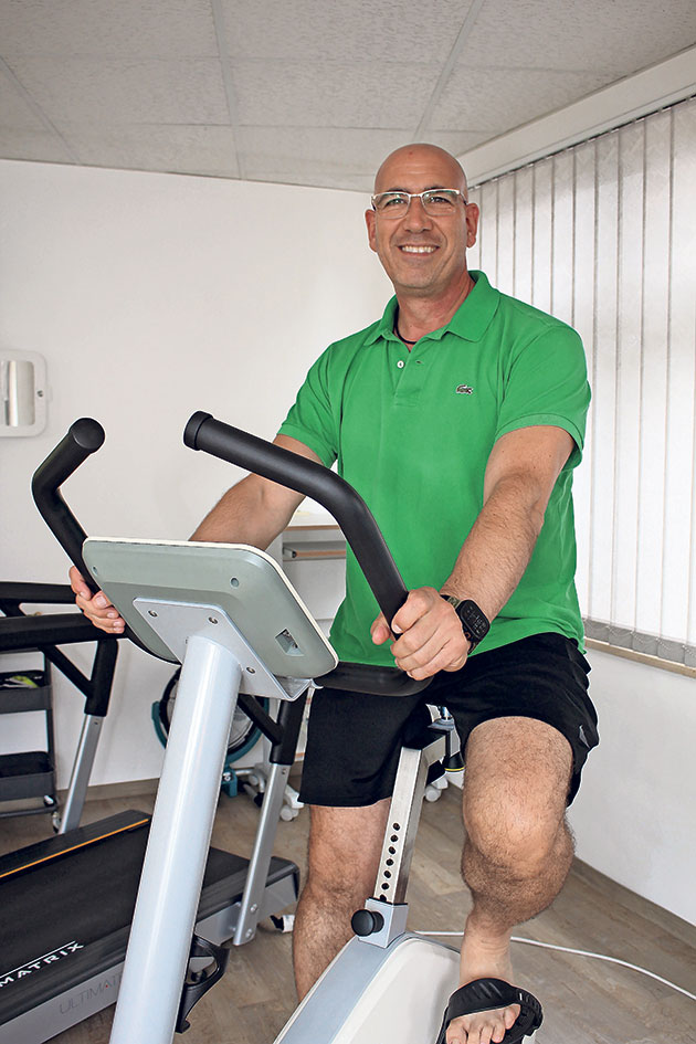 Mann auf Heimtrainer im Fitnessraum.