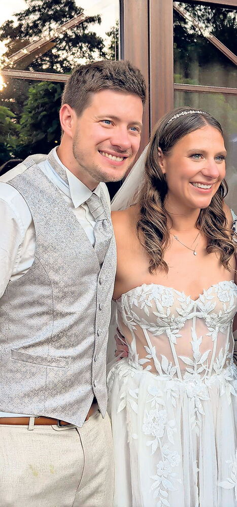 Brautpaar lächelt bei einer Hochzeit im Freien
