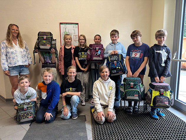 Gruppenfoto von Schulkindern mit Rucksäcken Schulkinder mit Rucksäcken posieren für ein Gruppenfoto.