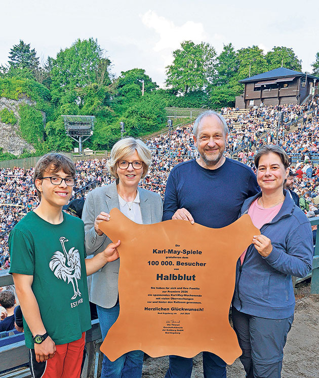 100.000. Besucher bei den Karl-May-Spielen ausgezeichnet Vier Personen halten eine Auszeichnung bei Karl-May-Spielen.