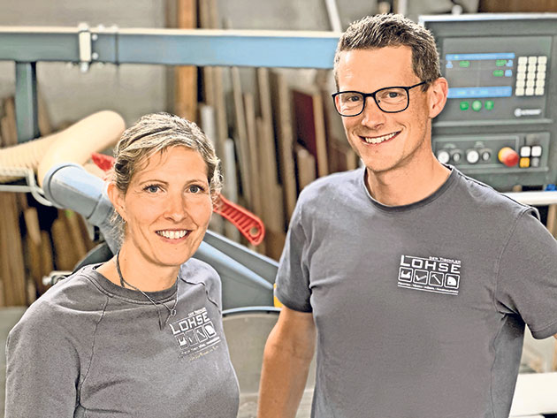 Mann und Frau in Werkstatt vor Holzbearbeitungsmaschine