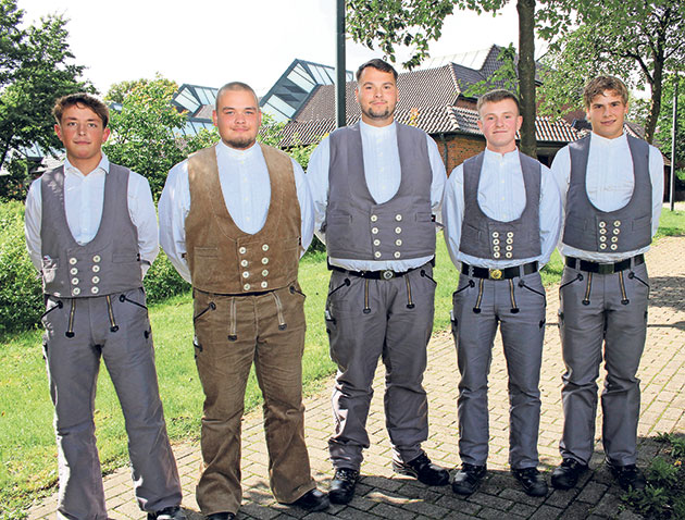 Gruppe junger Männer in traditioneller Kleidung draußen. Fünf Männer in traditioneller Kleidung im Freien.