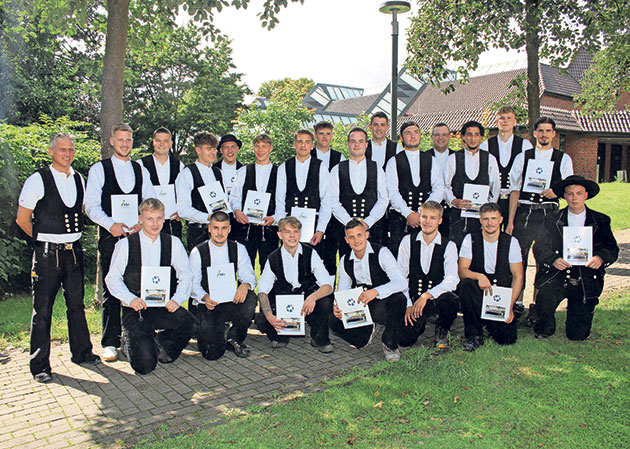 Traditionell gekleidete Zimmermänner Gruppe junger Männer in traditioneller Zimmermannskleidung.