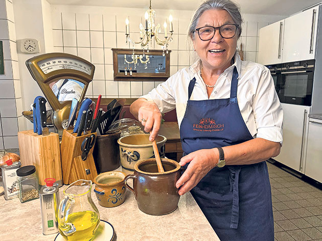 Kochen in der heimischen Küche Frau rührt in einem Tontopf in einer gemütlichen Küche