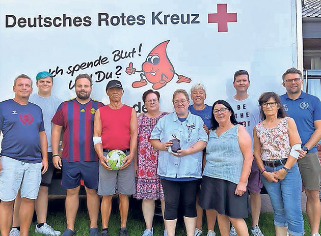 Gruppenfoto vor DRK-Fahrzeug. Gruppe posiert vor Deutsches Rotes Kreuz Fahrzeug.