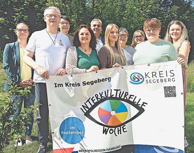 Personengruppe hält Banner für Interkulturelle Woche.