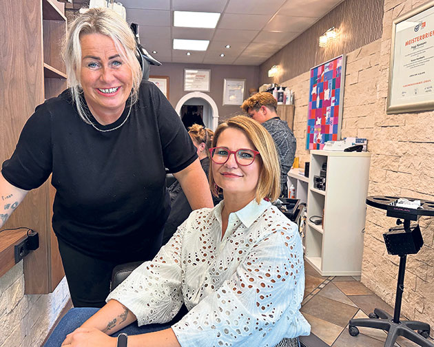 Friseursalon mit zwei Frauen beim Haarschnitt Zwei Frauen im Friseursalon, eine sitzt, eine steht.