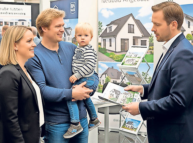 Hauskaufberatung mit Makler und Familie Familie bespricht Hauskauf mit Immobilienmakler.