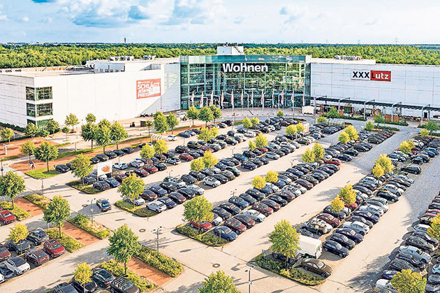 Luftaufnahme eines Möbelhauses mit Parkplatz Großes Möbelhaus mit Parkplatz voller Autos