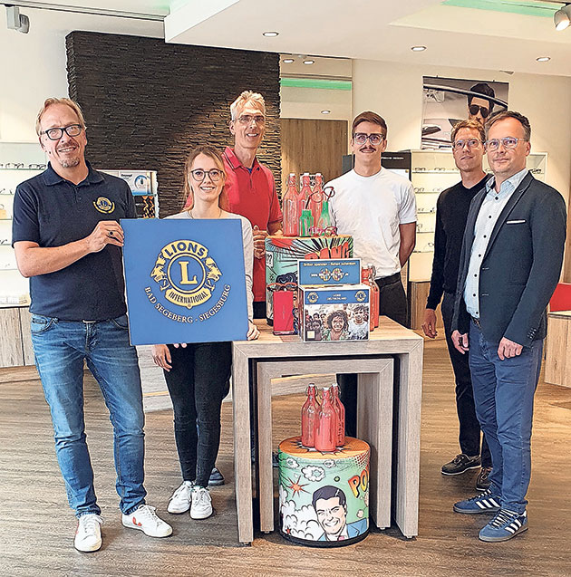 Sechs Personen posieren mit Lions-Club-Logo und Geschenken.