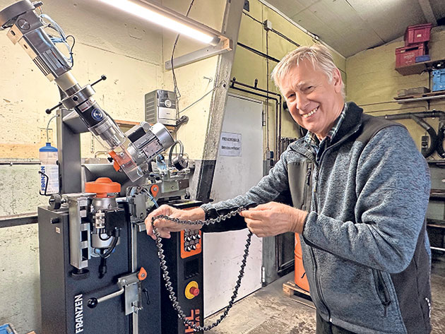 Mann mit Maschine in einer Werkstatt Ein Mann arbeitet an einer Maschinen in einer Werkstatt.