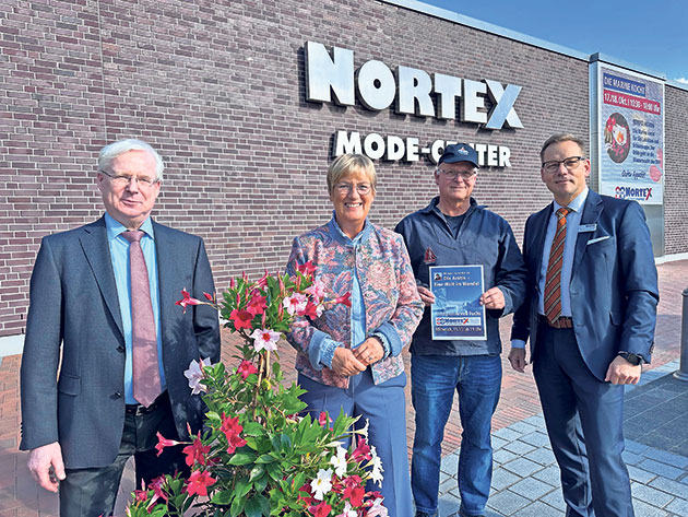 Gruppe steht vor dem Nortex Mode-Center. Vier Personen vor dem Nortex Mode-Center.