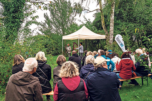 Gruppe von Menschen bei einer Outdoor-Veranstaltung unter einem Zelt.