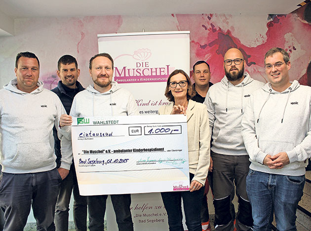 Scheckübergabe an das Kinderhospiz Die Muschel. Gruppe präsentiert Scheck über 1000 Euro für Kinderhospiz.