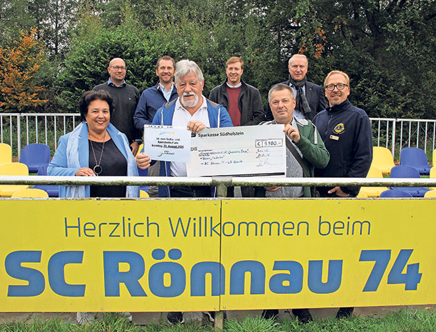 Gruppe mit Scheck vor SC Rönnau 74 Schild.