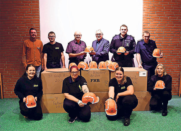 Feuerwehrteam mit neuen Helmen Gruppe von Menschen präsentiert orange Helme.