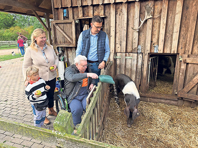 Familie füttert Schweine auf dem Land Gruppe füttert Schweine auf einem Bauernhof.