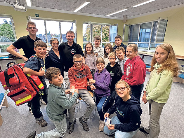 Schülergruppe mit Lehrern im Klassenzimmer. Gruppe von Schülern im Klassenzimmer mit zwei Erwachsenen.
