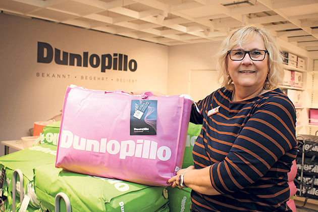 Frau hält eine rosa Dunlopillo-Tasche in einem Geschäft.