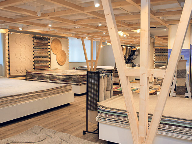 Ein Teppichladen mit Holzdecke und ausgestellten Teppichen.