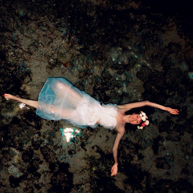 Schwimmen im Mondlicht Frau in weißem Kleid schwimmt im klaren Wasser.