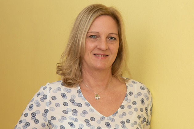 Lächelnde Frau vor gelbem Hintergrund.